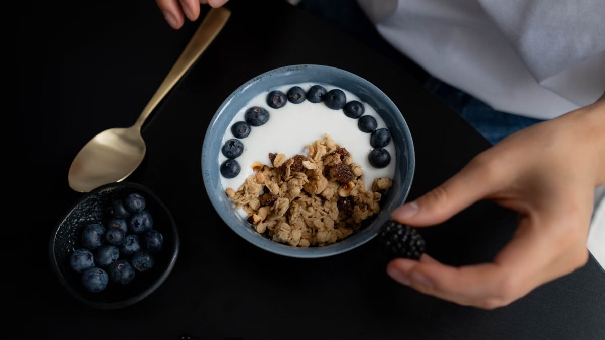 A delicious breakfast bowl featuring granola, yogurt, blueberries, and blackberries, perfect for a healthy start.